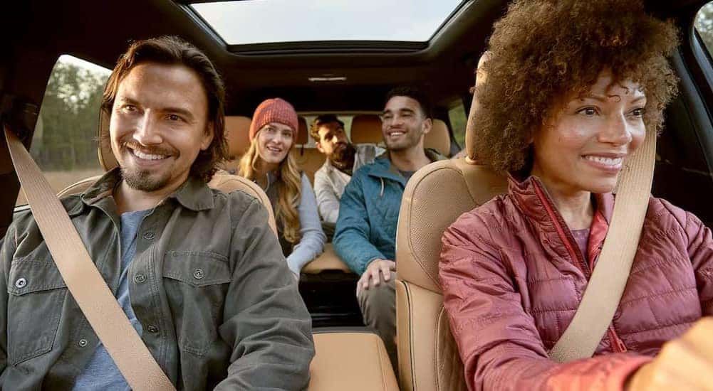 People are shown sitting in the brown interior of a 2025 Jeep Grand Cherokee L.