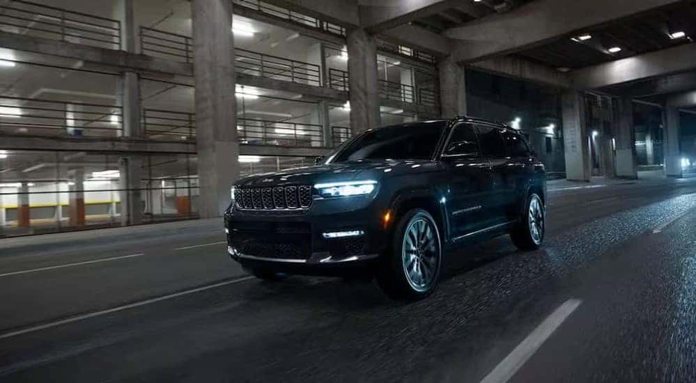 A black 2025 Jeep Grand Cherokee Loredo X is shown driving to view a Jeep Grand Cherokee for sale in Florence.