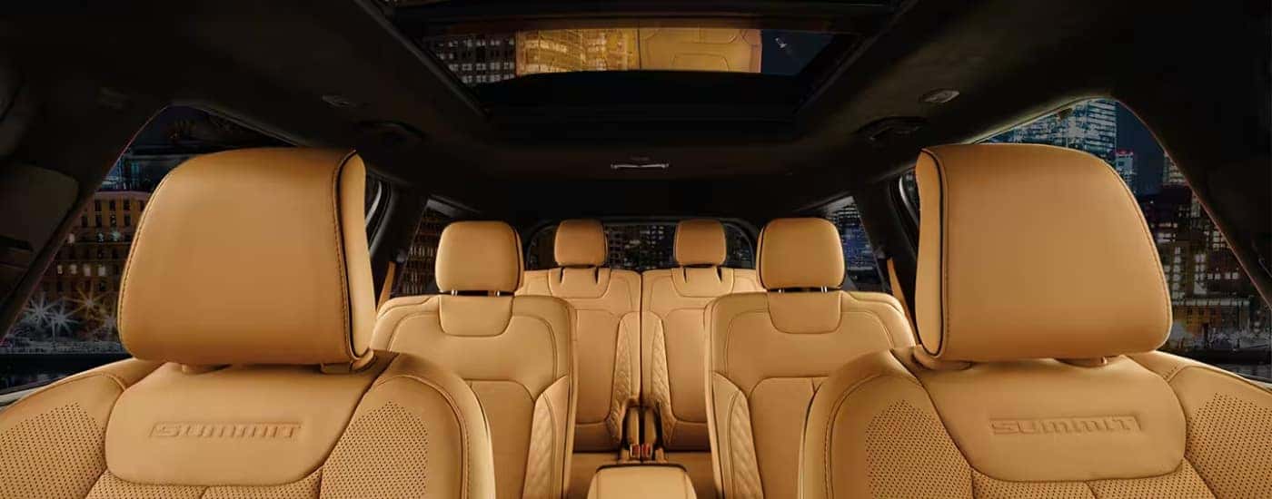 The tan interior of a 2025 Jeep Grand Cherokee L Summit is shown from the front looking back.