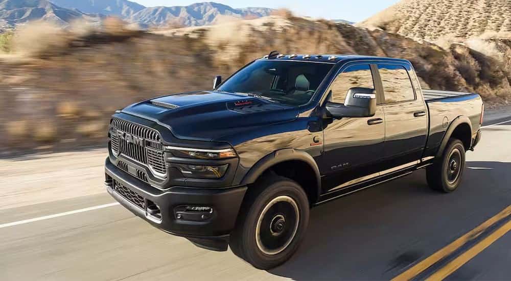 A black 2025 Ram 2500 is shown driving on a highway.
