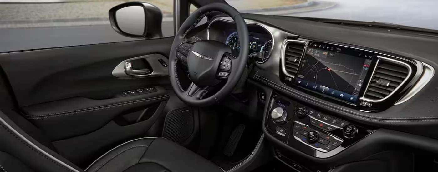 The black interior and dash are shown in a 2025 Chrysler Pacifica.