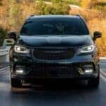 A black 2025 Chrysler Pacifica for sale near Cincinnati is shown driving on a highway.
