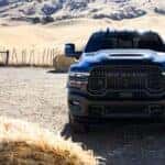 Head-on view of a black 2025 Ram 2500 Rebel parked near bales of hay.