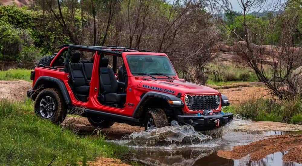 A red 2025 Jeep Wrangler Rubicon off-roading.