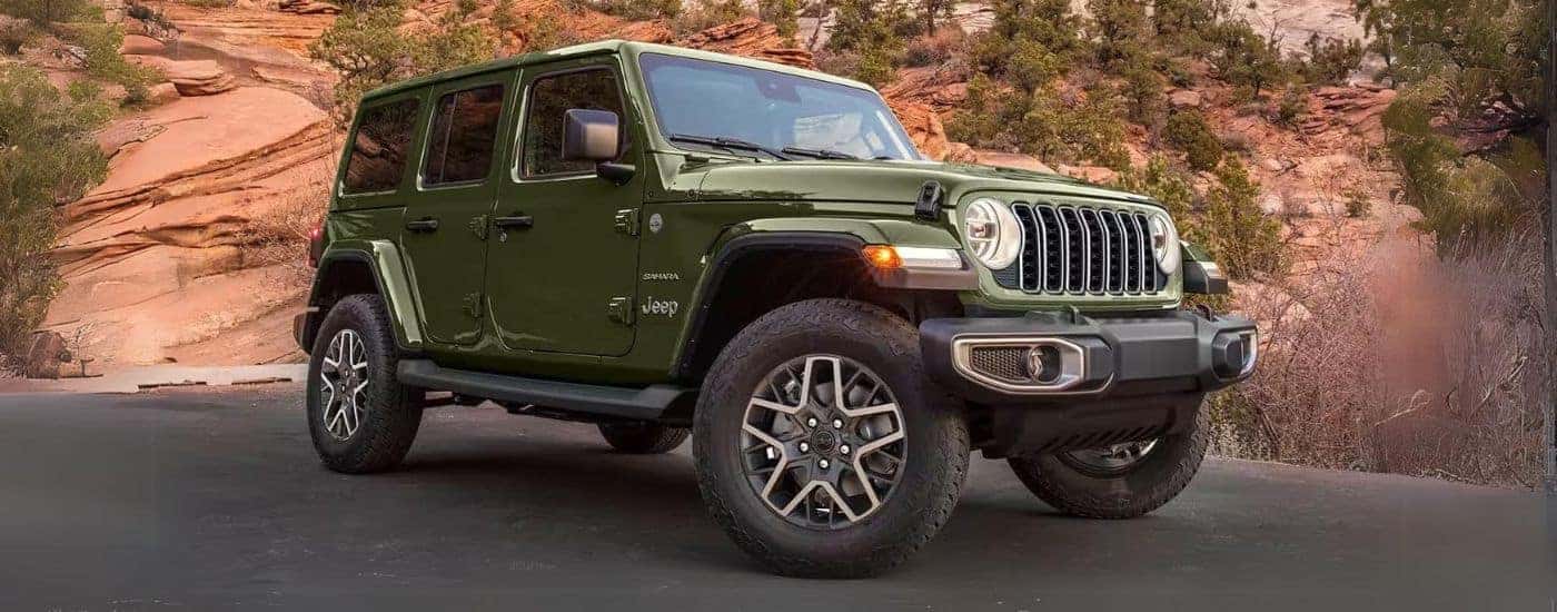 A dark green 2024 Jeep Wrangler Sahara Unlimited for sale near Cincinnati parked on a parking lot.