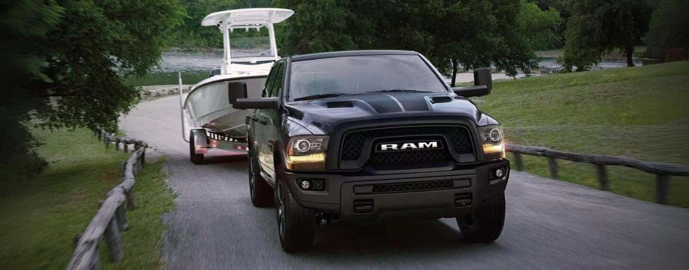 A black 2023 Ram 1500 Classic is driving to look at used trucks for sale near Burlington.