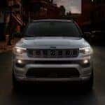 A silver 2025 Jeep Compass for Sale Near Cincinnati driving at night.