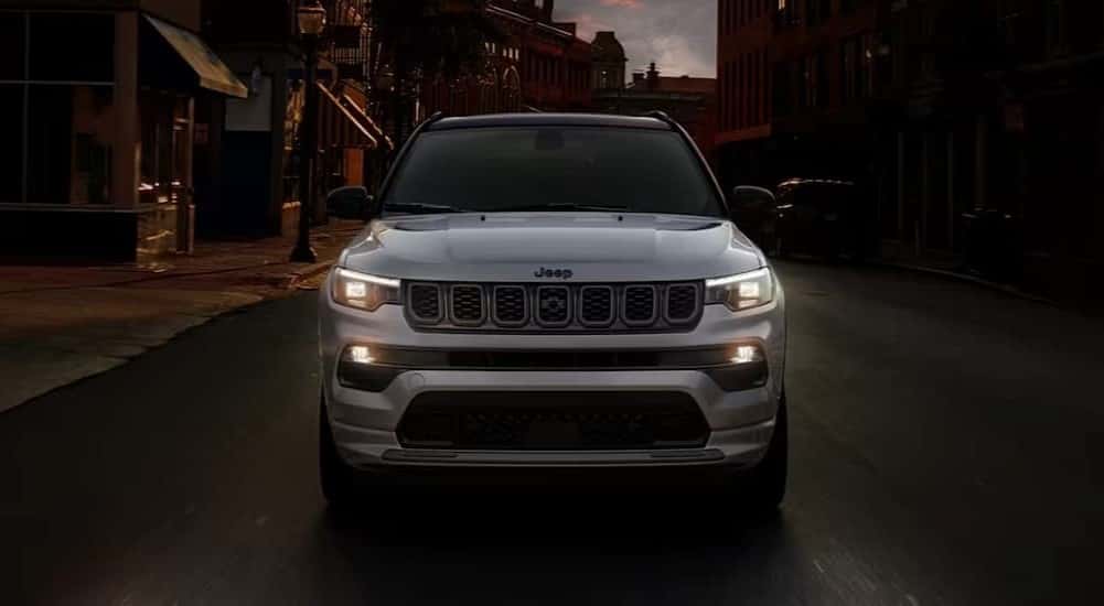 A silver 2025 Jeep Compass for Sale Near Cincinnati driving at night.
