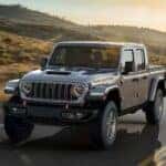 A silver 2025 Jeep Gladiator Mojave driving on a highway.
