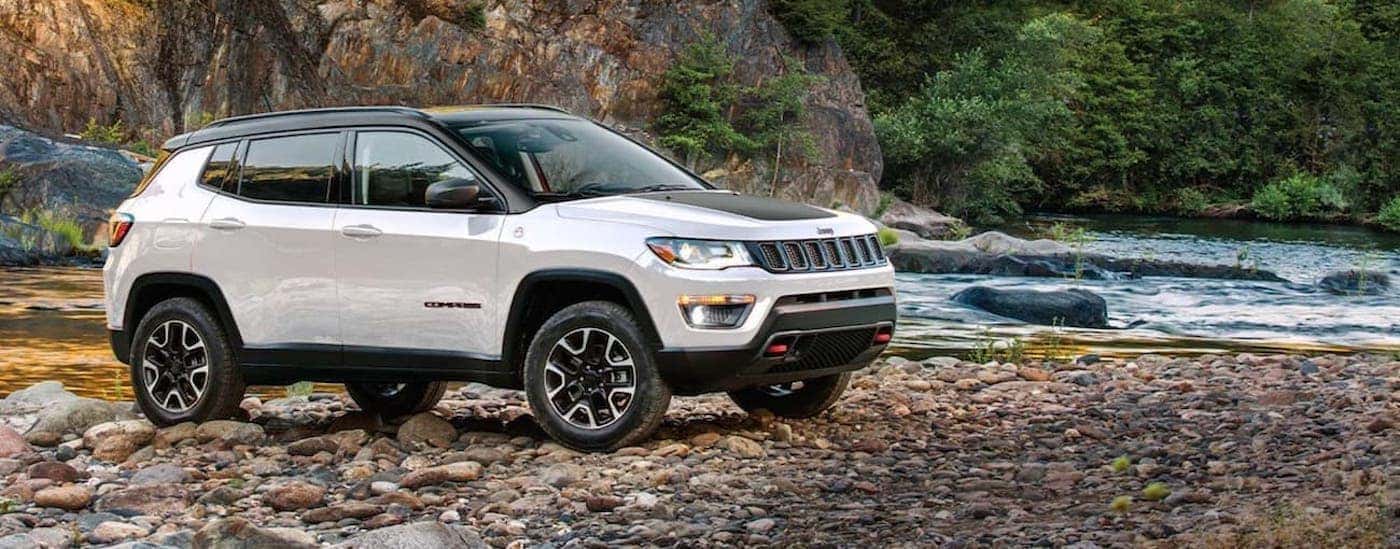 A white 2020 Jeep Compass Trailhawk parked by a river.