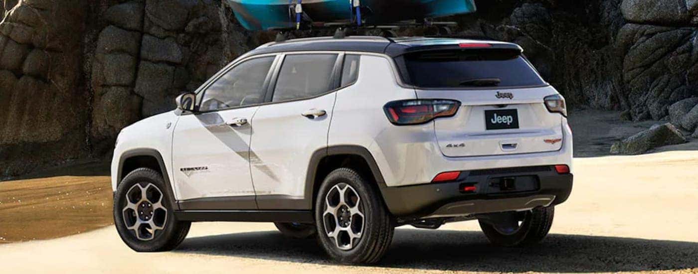 Rear view of a white 2022 Jeep Compass parked on a coast.