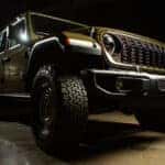 A green 2025 Jeep Wrangler 4xe Willys parked on conrete.