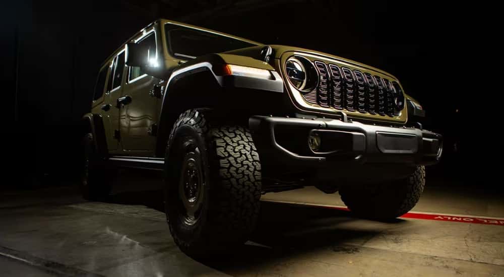 A green 2025 Jeep Wrangler 4xe Willys parked on conrete.