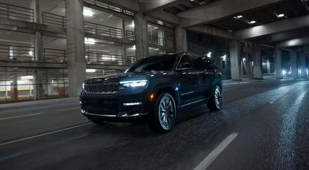 A black 2025 Jeep Grand Cherokee for sale near Cincinnati driving at night.
