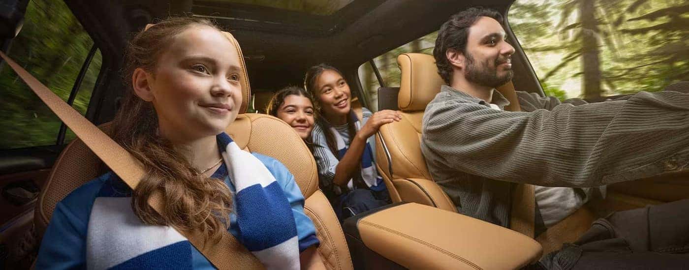 Several people driving in the brown interior of a 2025 Jeep Grand Cherokee L.