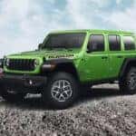 A green 2025 Jeep Wrangler Rubicon parked off-road.