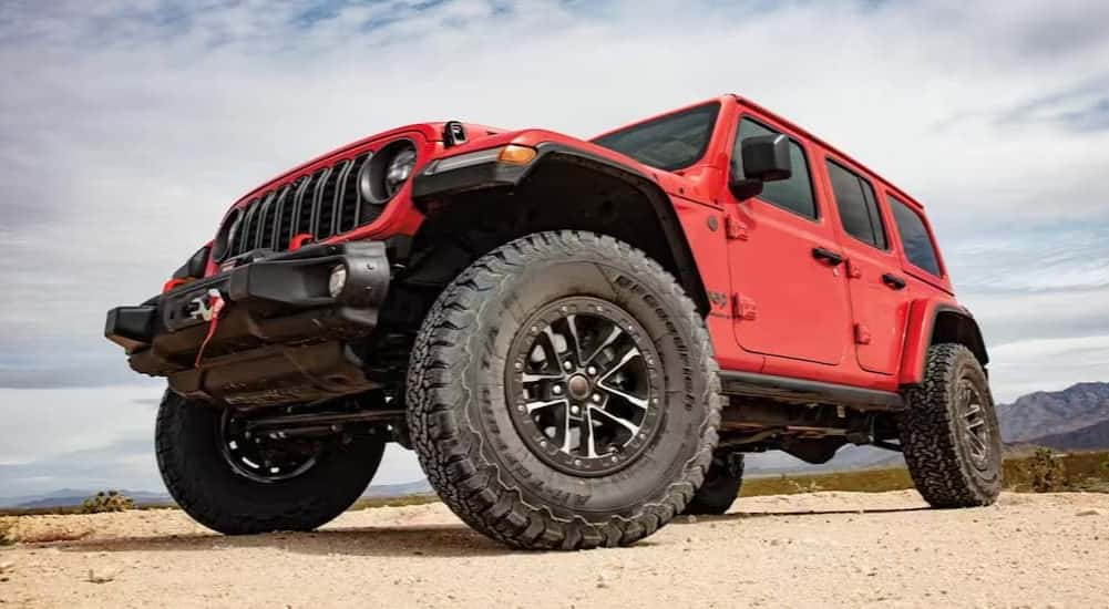A red 2025 Jeep Wrangler parked off-road.