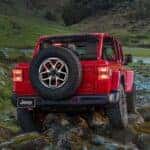 A red 2025 Jeep Wrangler for sale near Burlington off-roading.