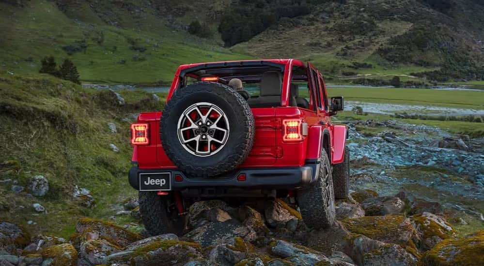 A red 2025 Jeep Wrangler for sale near Burlington off-roading.