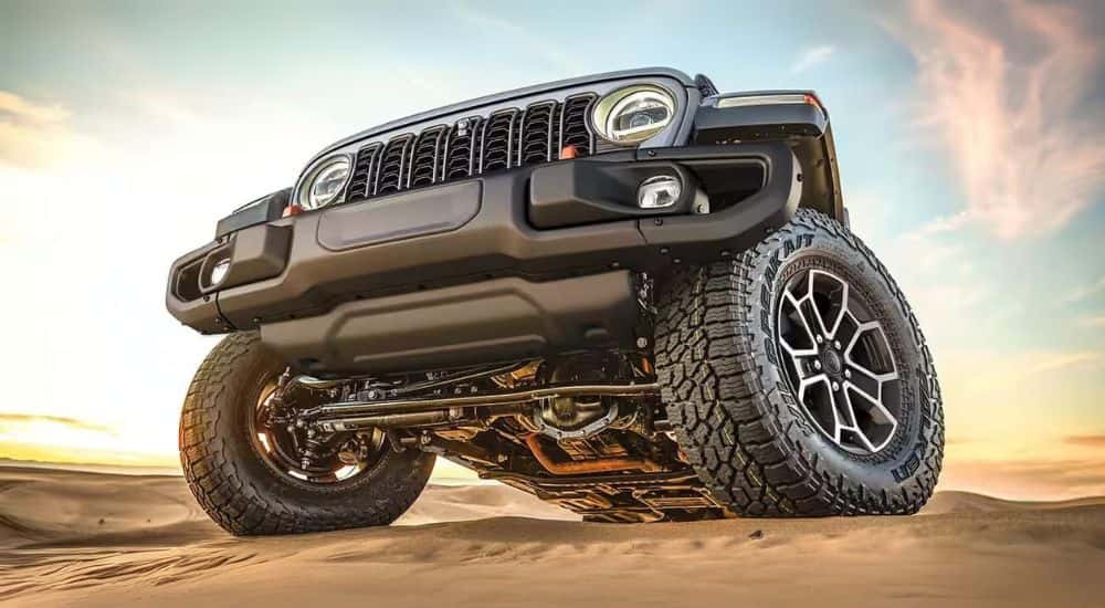Front grille on a black 2024 Jeep Gladiator off-roading on sand