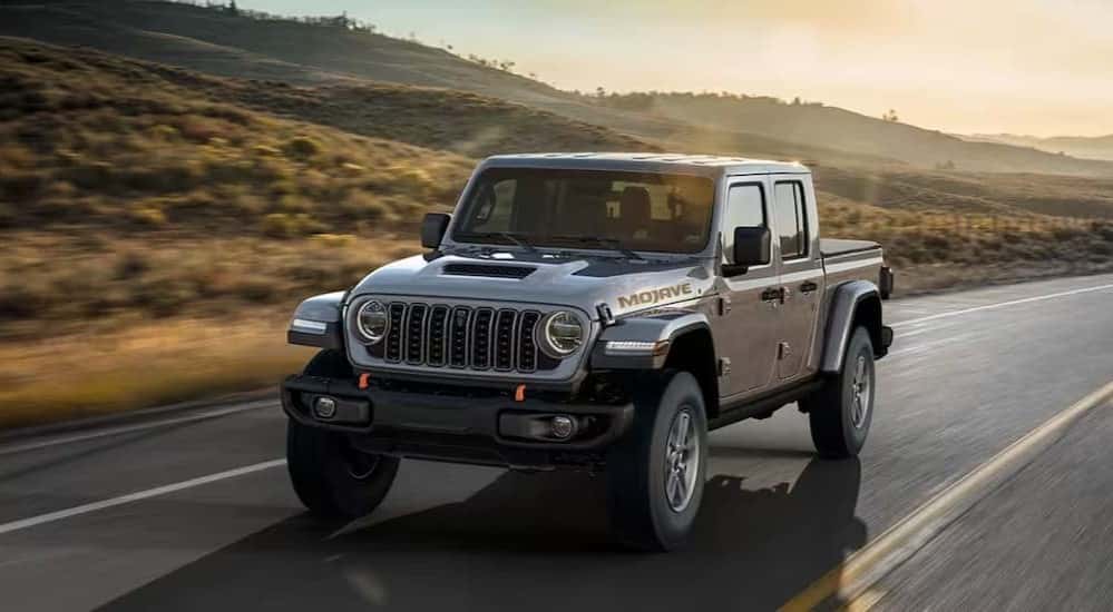 A gray 2025 Jeep Gladiator Mojave driving on a highway.