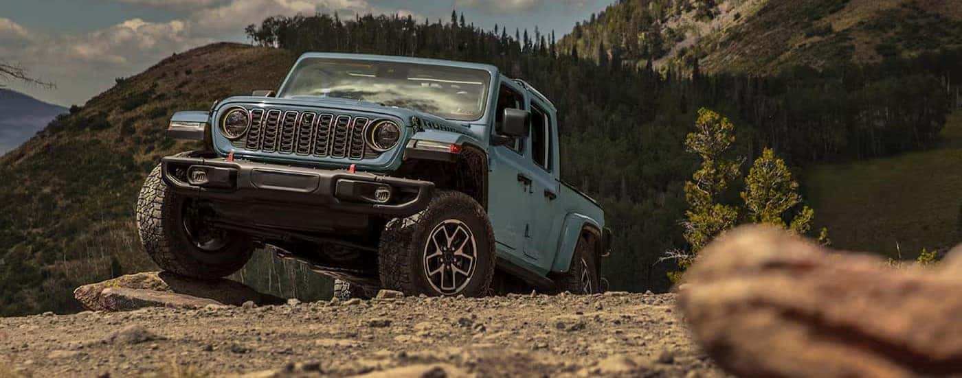 A blue 2025 Jeep Gladiator Rubicon off-roading.