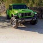 A green 2025 Jeep Gladiator Mojave parked off-road.