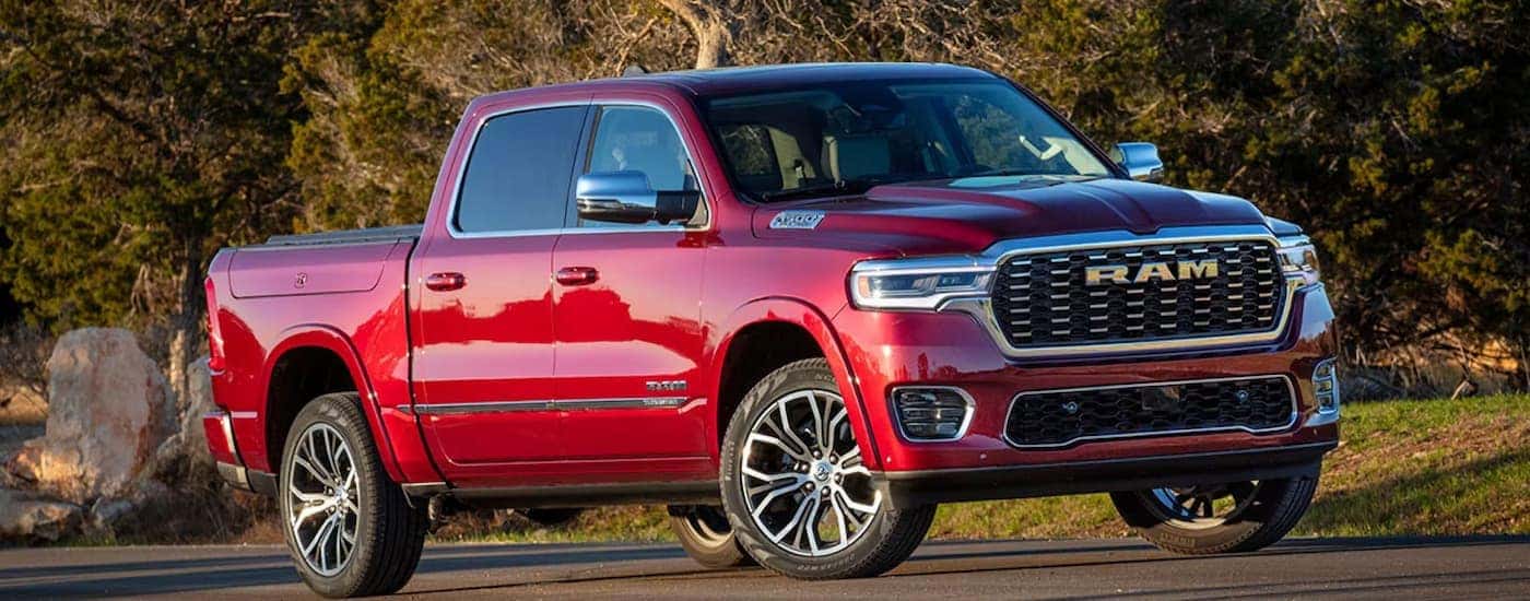 Red 2025 Ram 1500 Tradesman driving down a road.