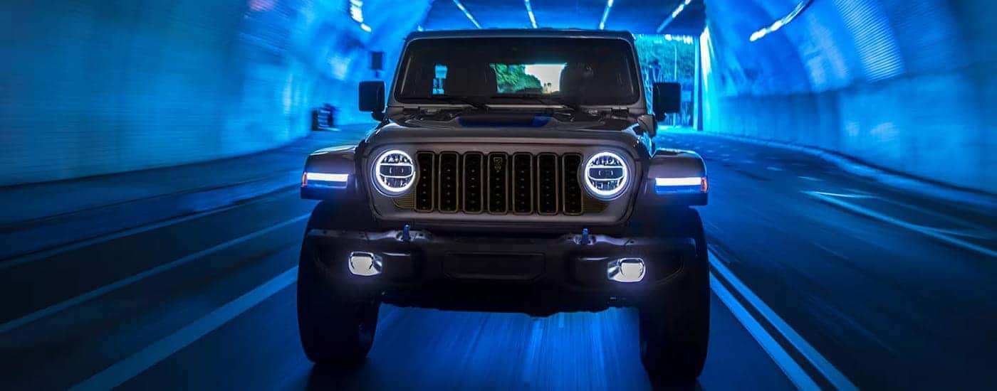Front of a grey 2024 Jeep Wrangler driving through a tunnel.