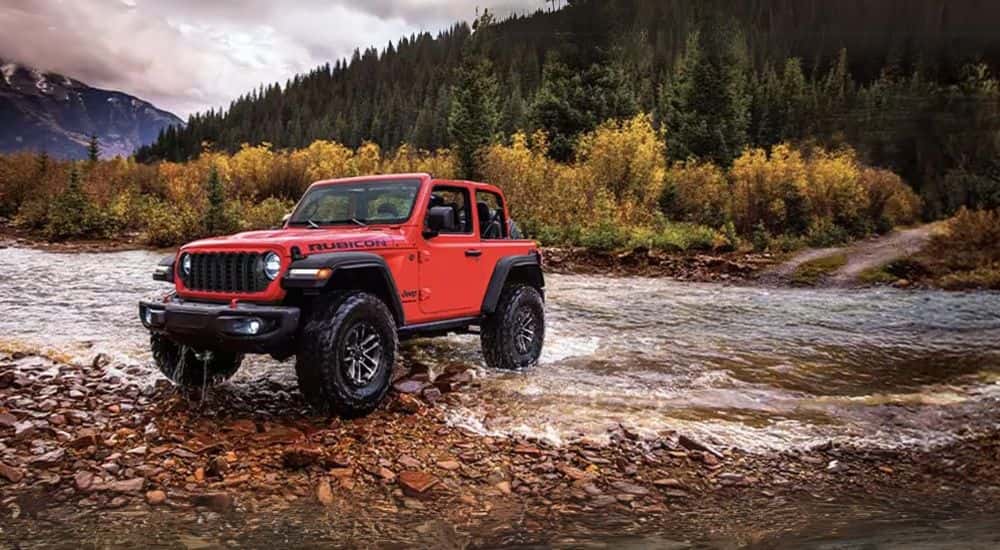 Red 2025 Jeep Wrangler Rubicon for sale near Alexandria driving through a river