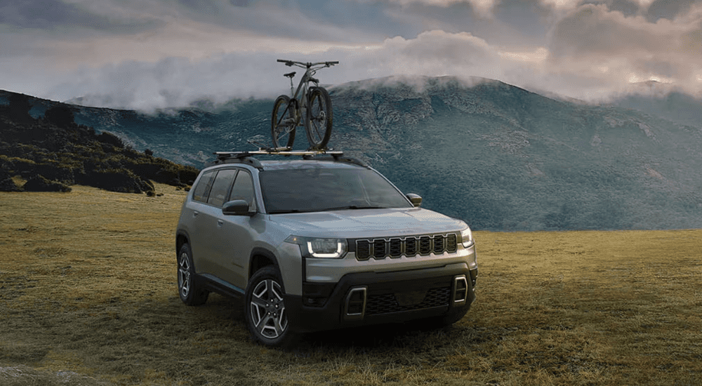 Silver 2026 Jeep Cherokee off road with a bike rack