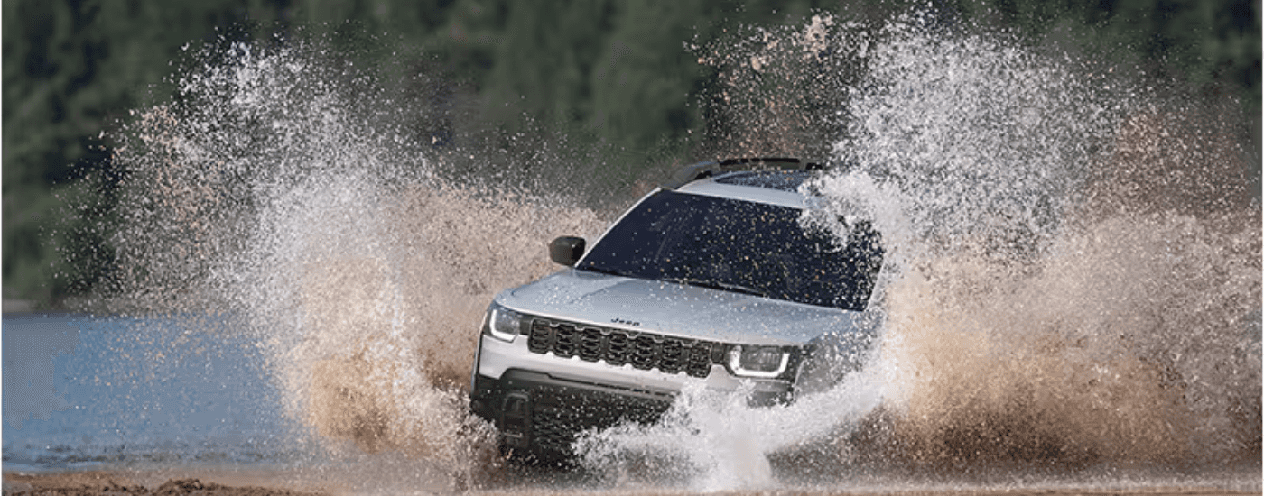 Silver 2026 Jeep Cherokee kicking up water