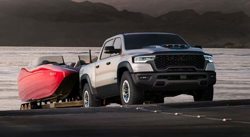 Silver 2026 Ram 1500 RHO is towing a boat