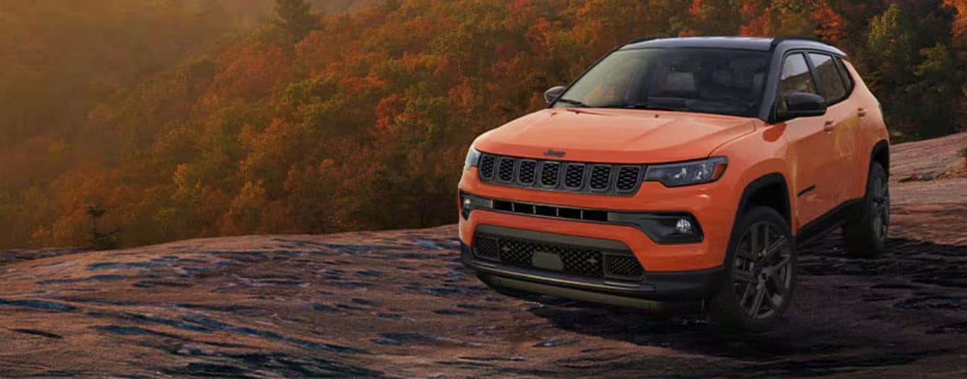 An orange 2025 Jeep Compass from the front.