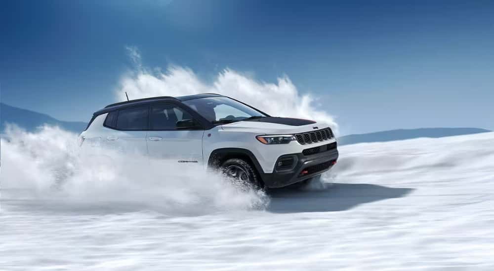White 2026 Jeep Compass Trailhawk kicking up snow