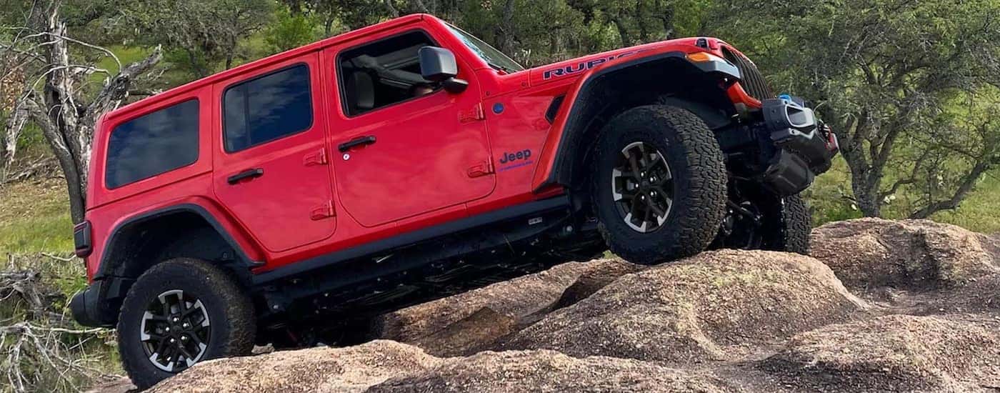 a red 2026 Jeep Wrangler from the side after leaving a Jeep dealer near Rising Sun.