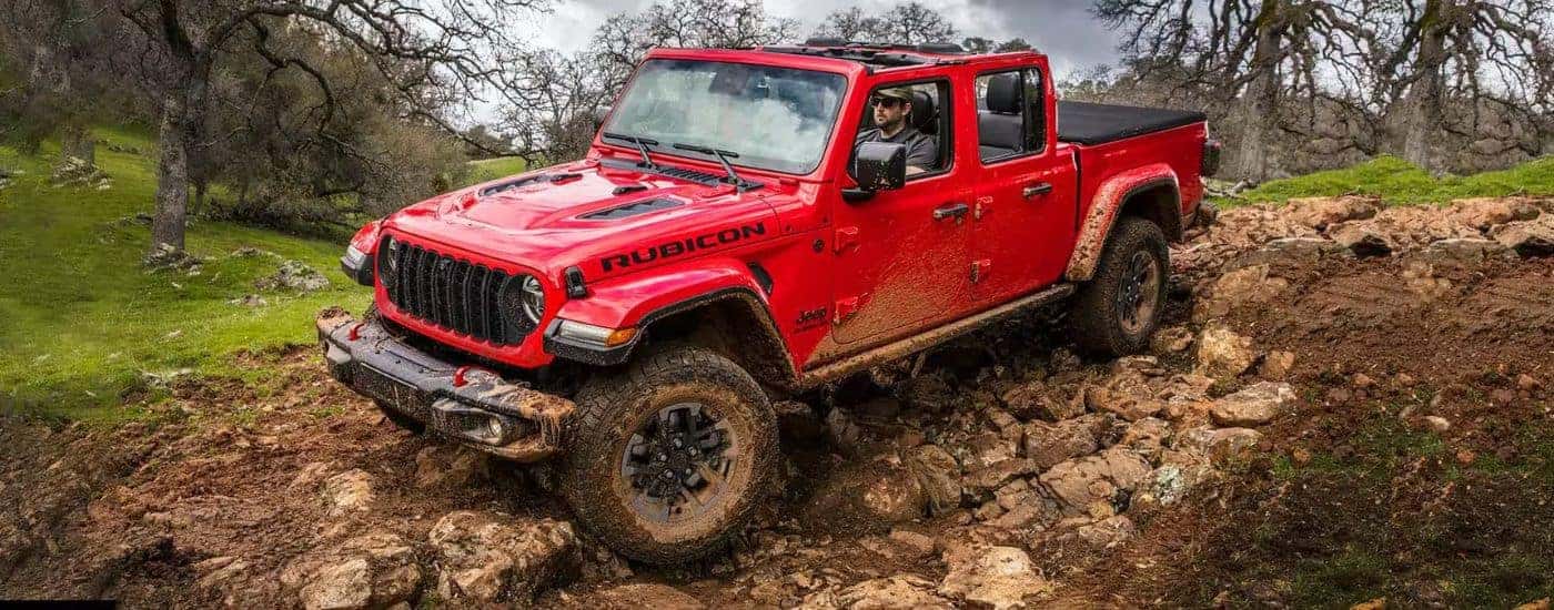A red 2024 Jeep Gladiator Rubicon off-roading from a dealer near Vevay