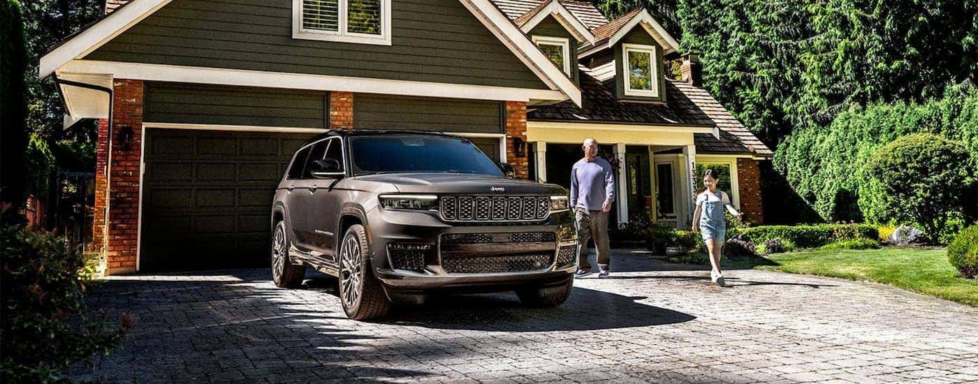 A gray 2025 Jeep Grand Cherokee parked in a driveway