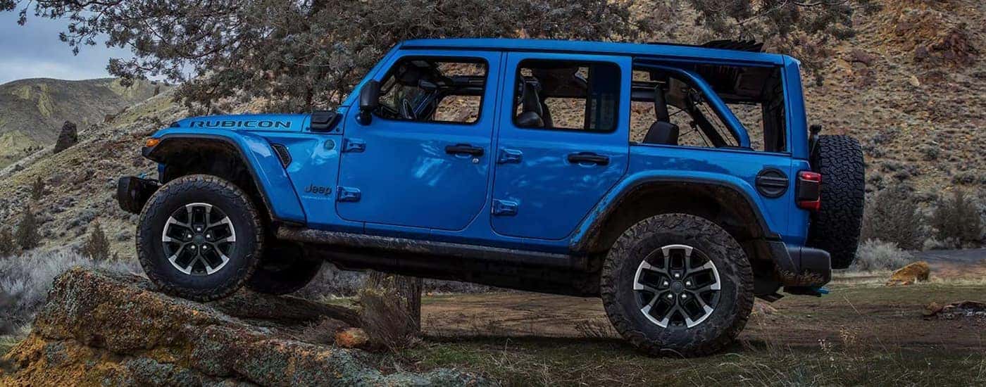 A blue 2025 Jeep Wrangler Rubicon off-roading from a dealer near Lawrenceburg