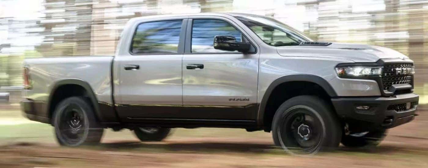 A silver 2025 Ram 1500 off-roading on a trail