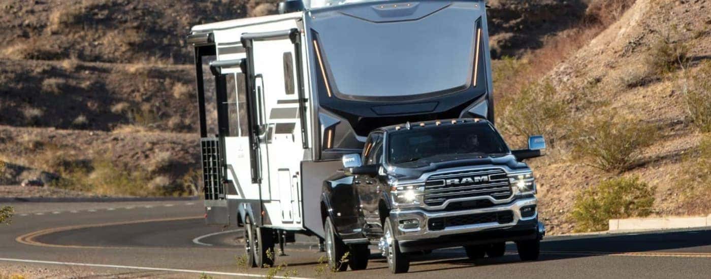 A black 2026 Ram 3500 towing a camper behind