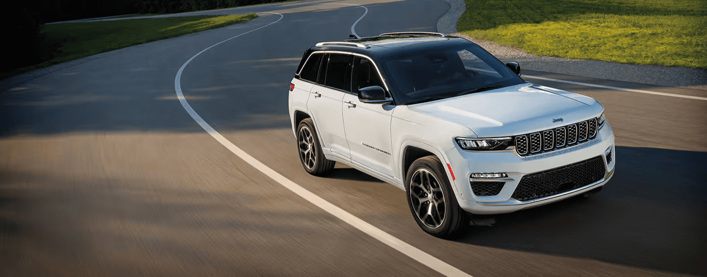 White 2026 Jeep Cherokee rounding a bend