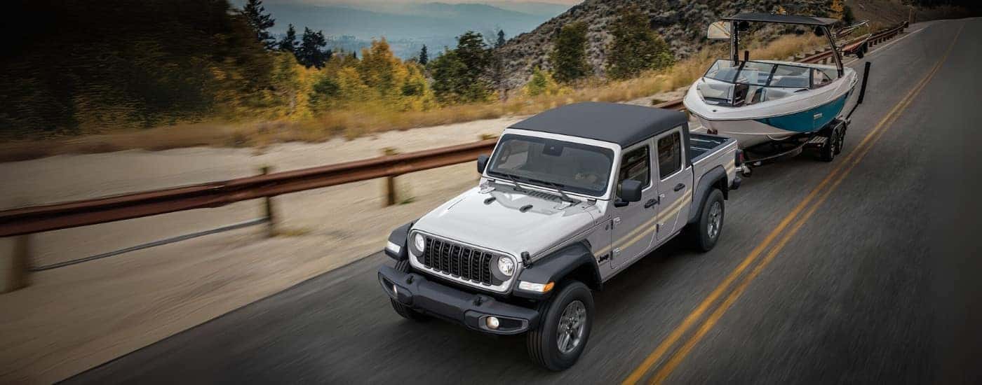 Silver 2025 Jeep Gladiator towing a boat