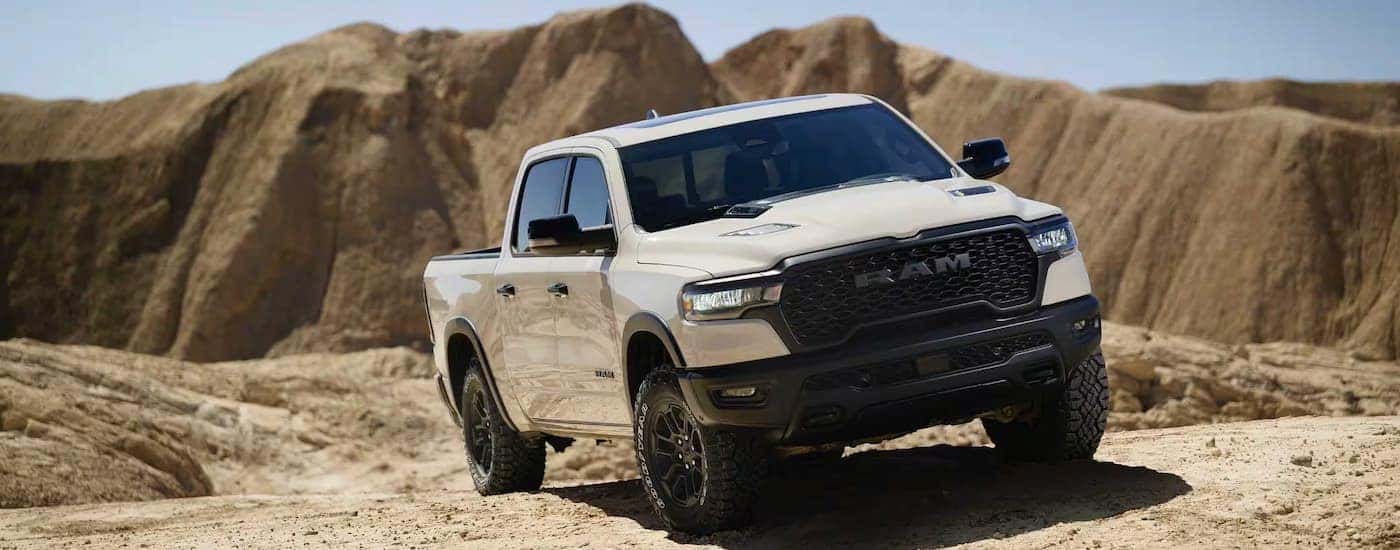White 2025 Ram 1500 Rebel parked off-road.