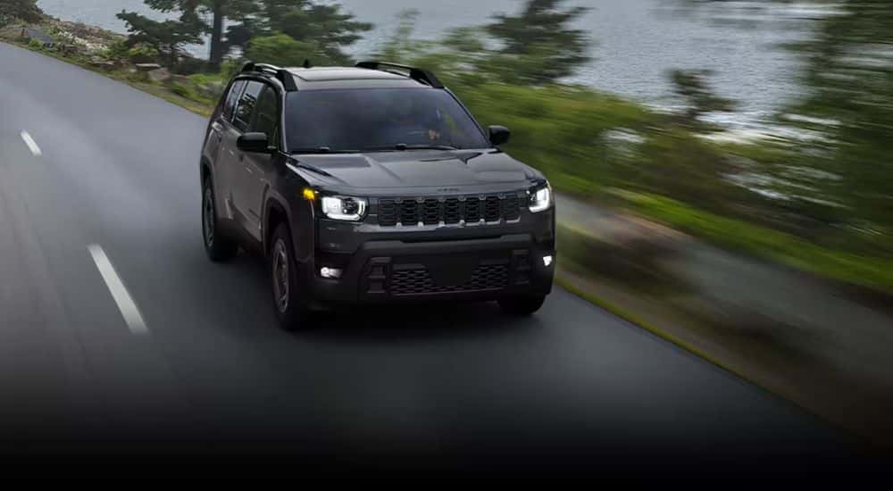 Black 2026 Jeep Cherokee Limited driving down the road