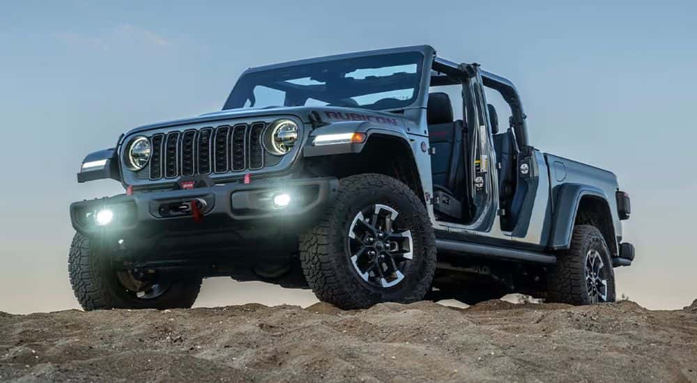 Gray 2026 Jeep Gladiator Rubicon X edition with no doors or roof on a rocky hill