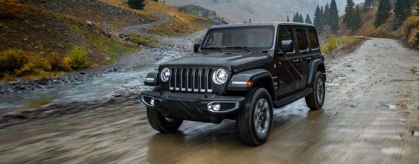 Black 2018 Jeep Wrangler on a muddy road