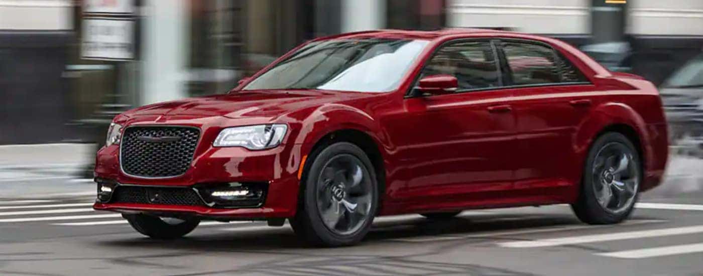 Red 2021 Chrysler 300 driving in the city
