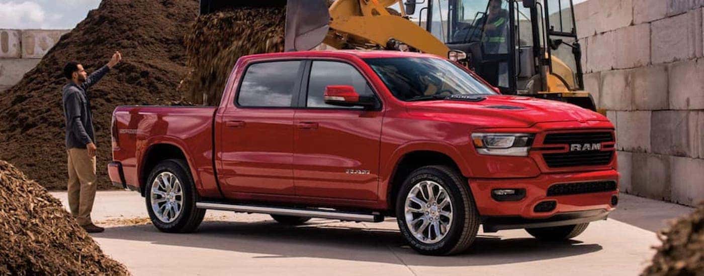 Red 2021 Ram 1500 getting mulch loaded into the bed