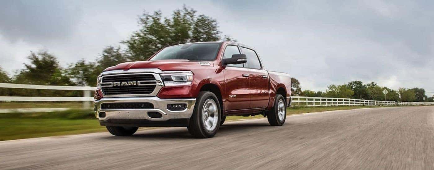 Red 2021 Ram 1500 driving on a dirt road on a ranch